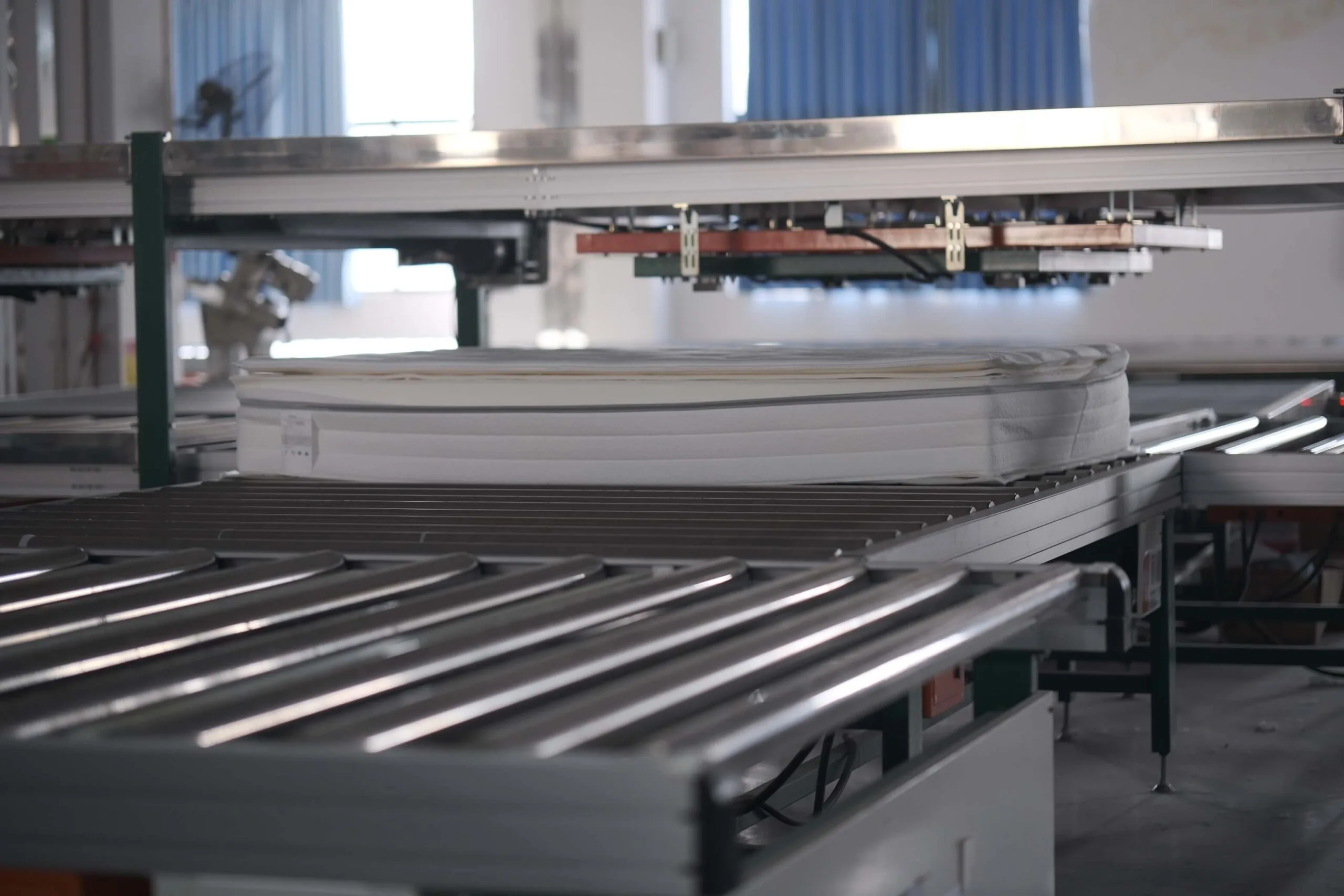 Mattress sliding through an automated machine on the production line