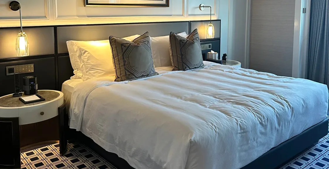 A luxury hotel bedroom with a pocket spring mattress, soft lighting, and elegant modern decor