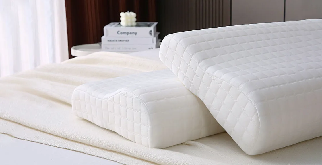 Two white memory foam pillows stacked on a bed 