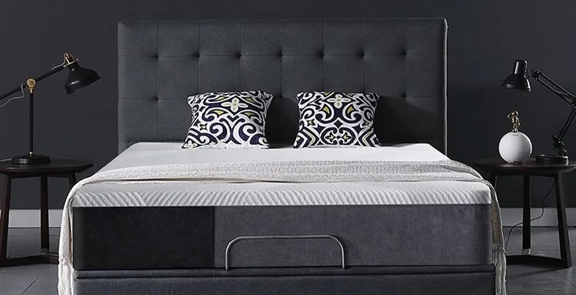 Memory foam mattress on a dark upholstered bed frame in a modern bedroom