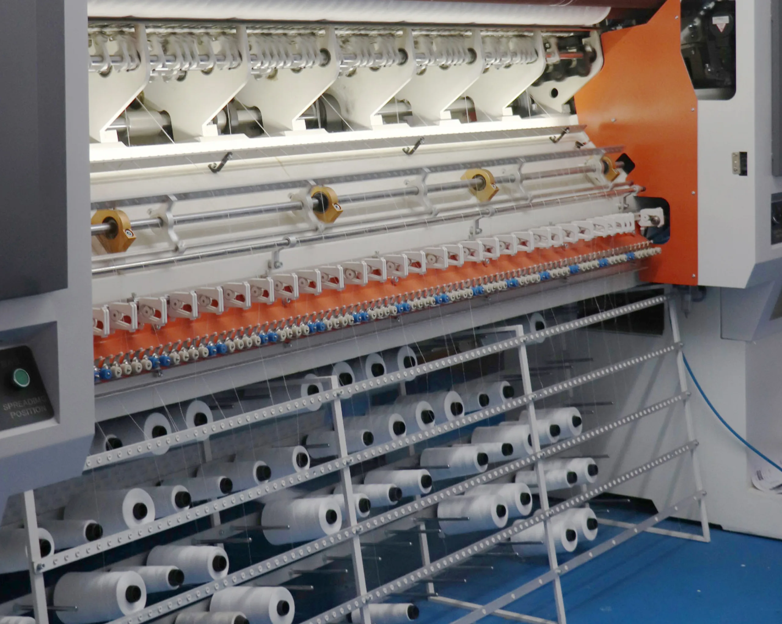 Quilting machine operating on mattress fabric, creating uniform patterns while enhancing comfort and support